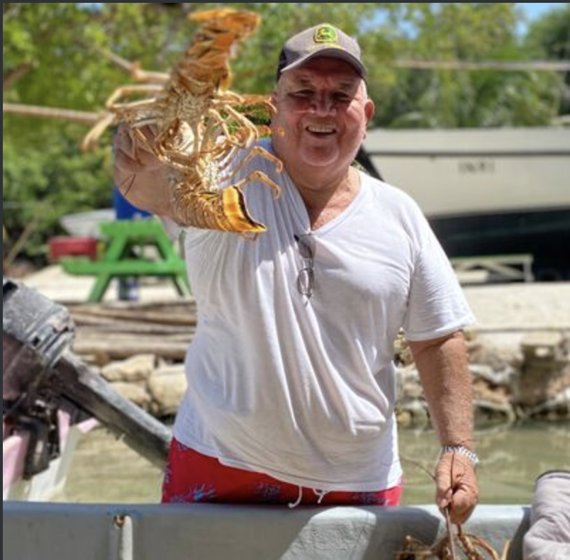 Melvin Badillo, founder and owner of M&N Guest House, holding a freshly caught Caribbean lobster